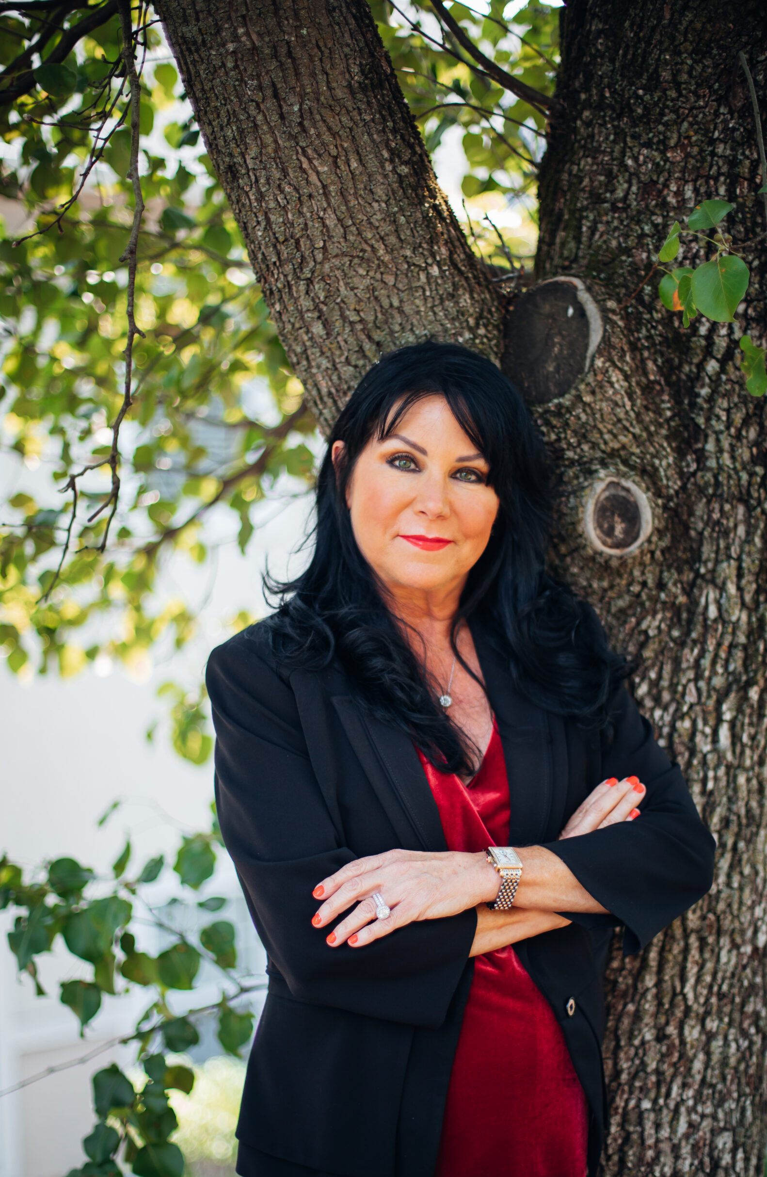 Paula Robinson, attorney, posing for an outdoor portrait next to a tree