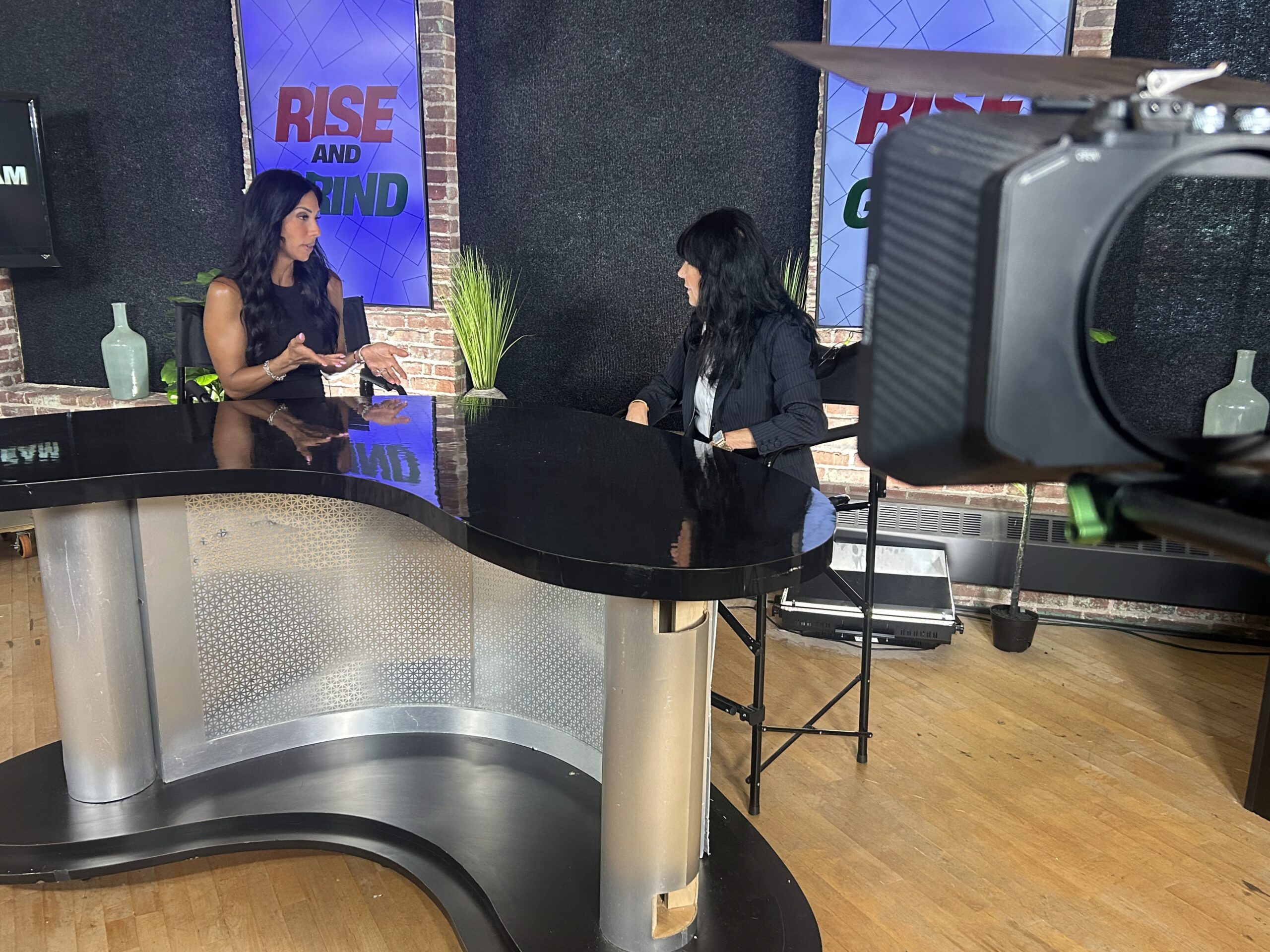 Television interview setup showing camera equipment and lighting aimed at interview subject from low angle